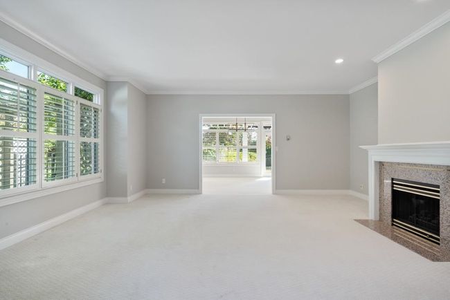 Unfurnished living room with a healthy amount of sunlight, ornamental molding, a high end fireplace, and baseboards | Image 6