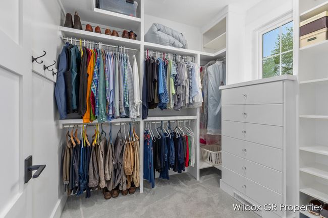 Spacious primary dressing closet is custom designed for efficient space. | Image 25