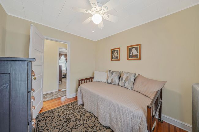Bedroom with baseboards, ceiling fan, wood finished floors, and ornamental molding | Image 18