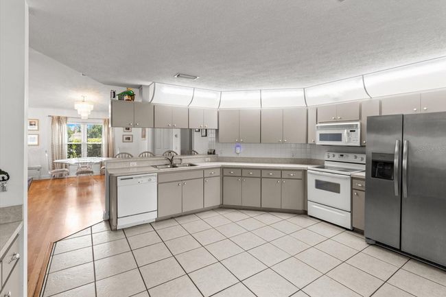 Kitchen w/ Tile Floor & Tiled Backsplash | Image 17