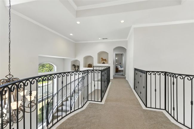 Corridor with light carpet, recessed lighting, arched walkways, crown molding, and an upstairs landing | Image 28