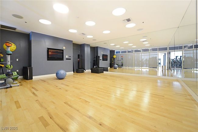 Workout room with baseboards, wood finished floors, and visible vents | Image 48