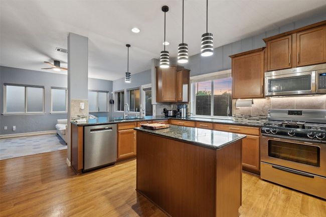 The kitchen boasts granite counters, stainless steel appliances including the refrigerator, center island plus the sink overlooks the back yard. | Image 10