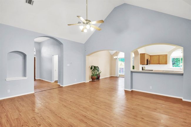 Living room featuring a ceiling fan, high vaulted ceiling, and light vinyl plank floors | Image 11