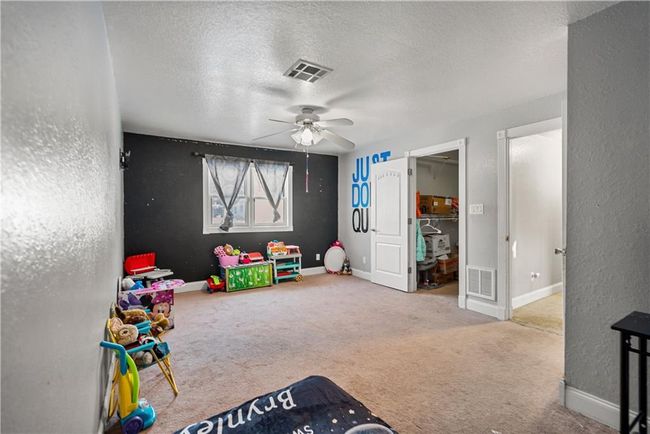 Rec room with ceiling fan, carpet flooring, and a textured ceiling | Image 44