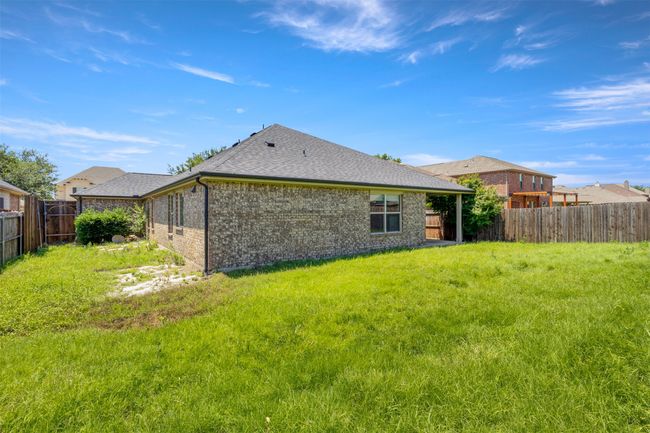 Back of property with brick siding, a fenced backyard, and a shingled roof | Image 30