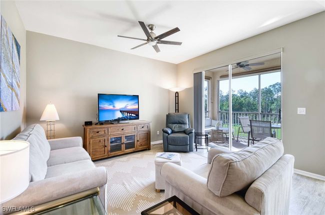 View of screened-in lanai with water and golf course views. | Image 4
