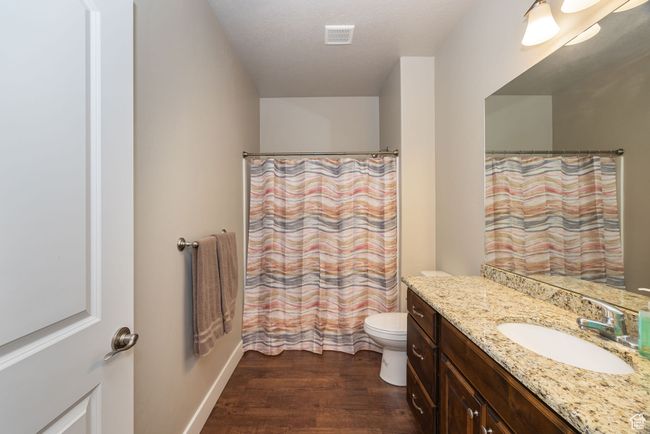 Bathroom featuring wood-type flooring, vanity, a textured ceiling, and toilet | Image 12