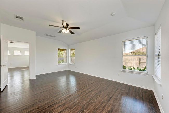 Primary bedroom with dark wood-like flooring, ceiling fan | Image 21