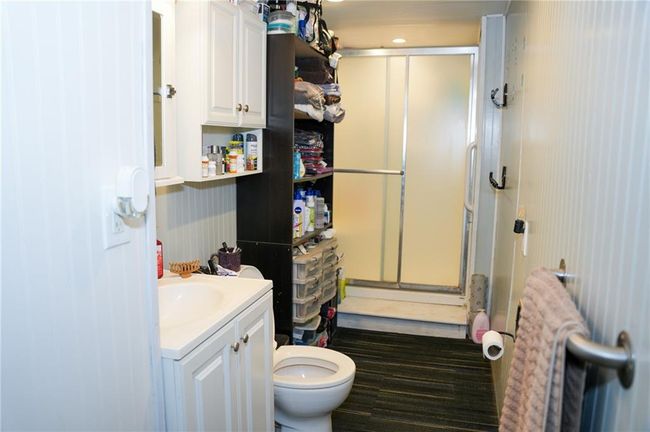 Bathroom with toilet, vanity, and a stall shower | Image 23