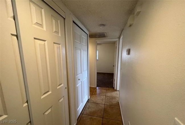 Corridor featuring a textured ceiling and dark tile patterned floors | Image 9