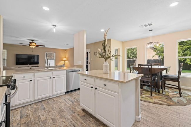The tasteful tile backsplash, freshly painted cabinets, and recess lighting add a designer touch to the kitchen’s clean, modern look. | Image 12