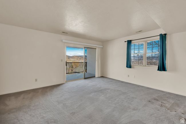 Carpeted spare room featuring baseboards, a wealth of natural light, and visible vents | Image 19