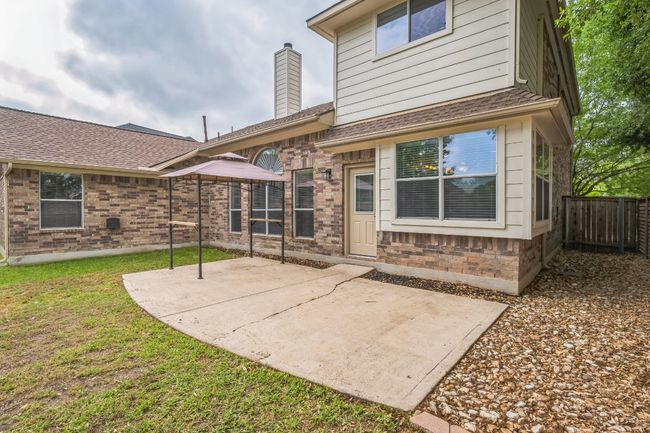 Back of property featuring fence, a chimney, brick siding, and a patio | Image 28