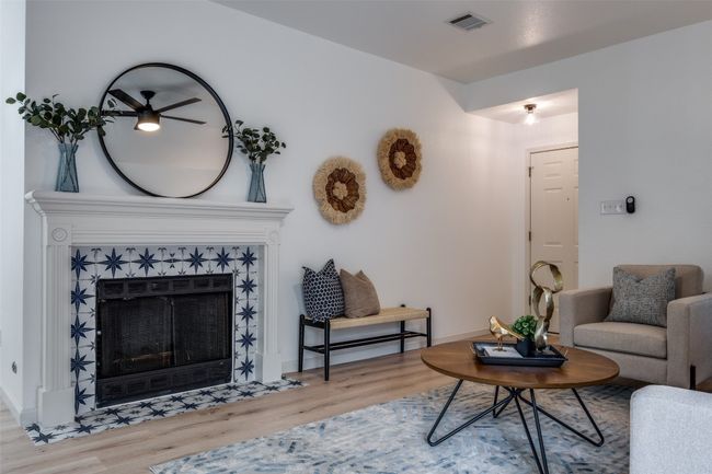 Living room with a tile fireplace, visible vents, and wood finished floors | Image 7