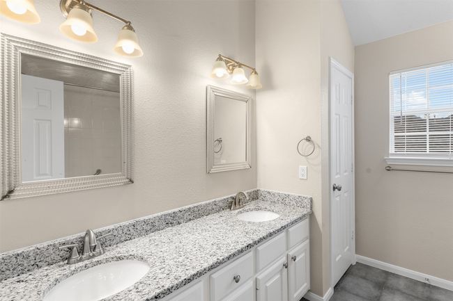 Bathroom with baseboards, double vanity, a sink, and tile patterned floors | Image 34