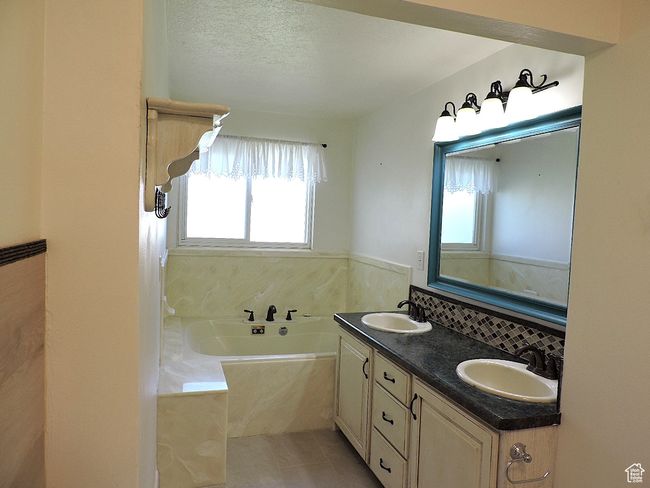 Full bath featuring a sink, tile patterned floors, a garden tub, and double vanity | Image 28