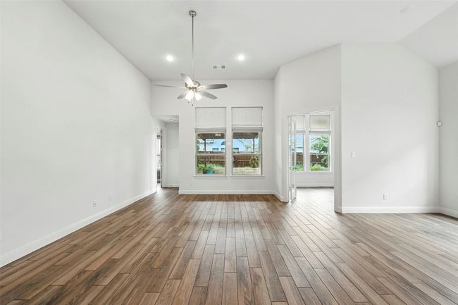 Unfurnished living room featuring tile floors, recessed lighting, a high ceiling, and a ceiling fan | Image 11