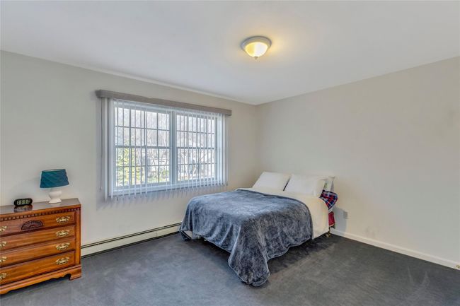 Carpeted bedroom featuring a baseboard heating unit | Image 17