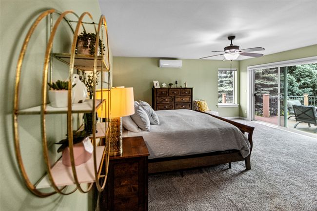 Carpeted bedroom with a wall unit AC, multiple windows, a ceiling fan, and access to exterior | Image 66