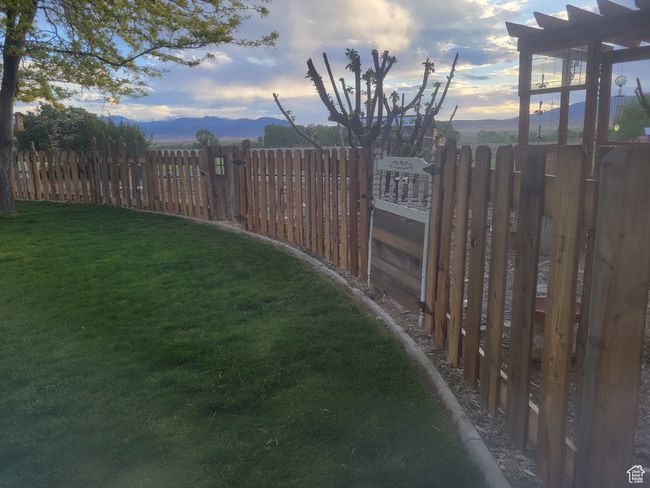 View of yard with a mountain view and fence | Image 51