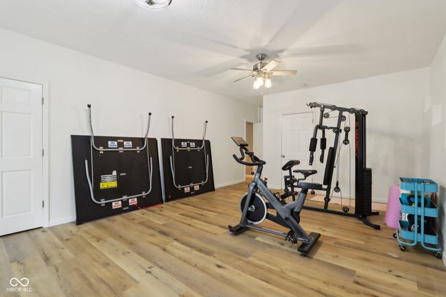 workout room with a ceiling fan, baseboards, and light wood finished floors | Image 48