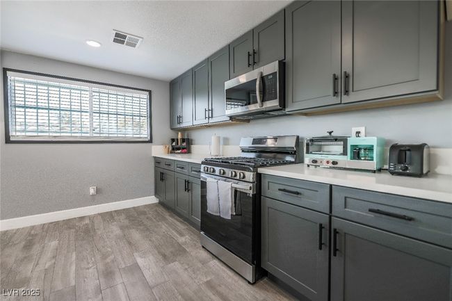 Kitchen featuring appliances with stainless steel finishes, baseboards, light countertops, light wood-style floors, and recessed lighting | Image 22