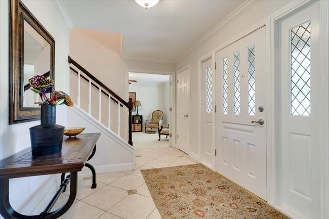 Entrance foyer featuring ornamental molding, stairs, light tile patterned flooring, and baseboards | Image 17