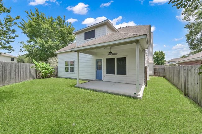 This view highlights the home's clean exterior, solar-type screens on most windows for energy efficiency, and a covered patio perfect for relaxation. Recent upgrades include a new back door and added ceiling fan for year-round comfort. | Image 37