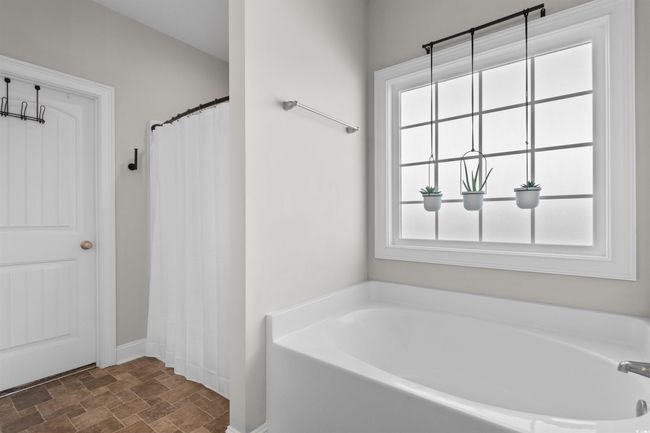 Full bathroom featuring stone finish floors and a garden tub | Image 19