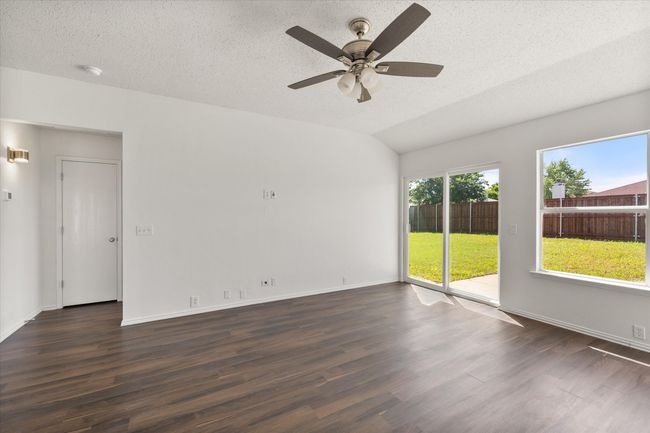 Den leading into the Primary suite with wood finished floors, ceiling fan, a textured ceiling, and baseboards | Image 12