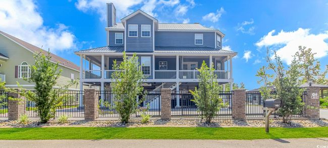View of front of house with a metal roof, a sunroom, a standing seam roof, and a chimney | Image 4