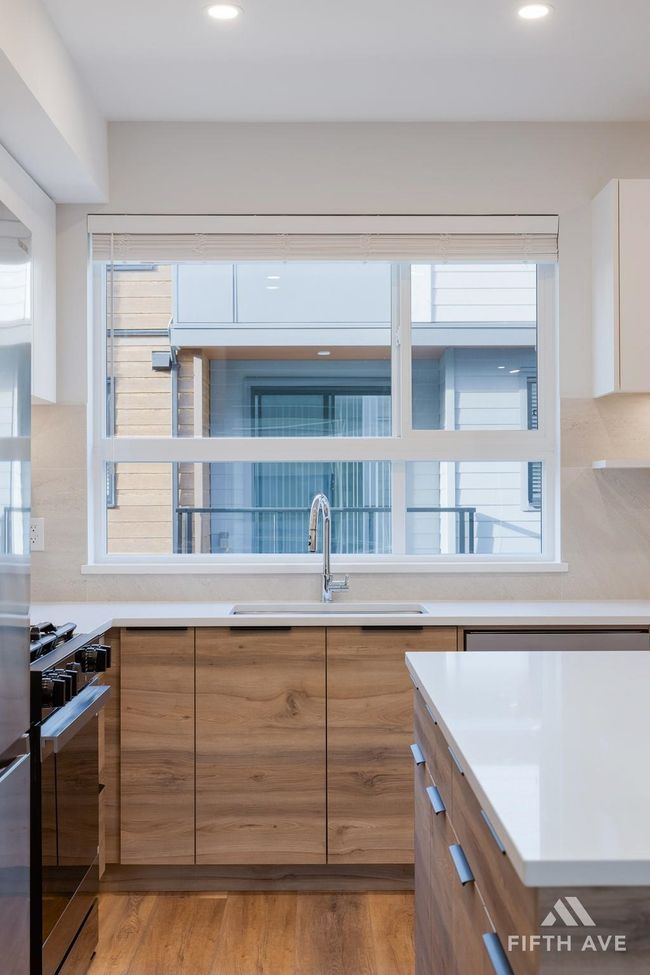 Kitchen featuring range with gas stovetop, modern cabinets, backsplash, light countertops, and recessed lighting | Image 20