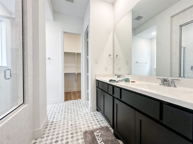 Full bathroom with a stall shower, double vanity, a spacious closet, and tile patterned floors | Image 21
