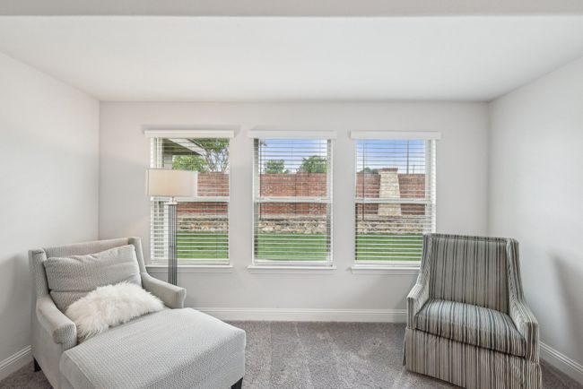 Sitting area in primary bedroom with view of backyard. The brick and stone wall is the responsibility of the HOA. There are no back neighbors behind the home. | Image 23