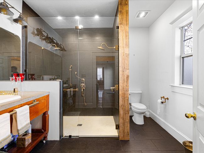 Bathroom featuring visible vents, toilet, a shower stall, tile patterned flooring, and vanity | Image 19