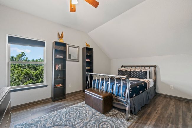 Bedroom featuring lofted ceiling, a ceiling fan, baseboards, and wood finished floors | Image 24