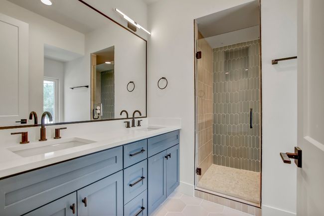 Bathroom with double vanity, a stall shower, and tile patterned flooring | Image 20