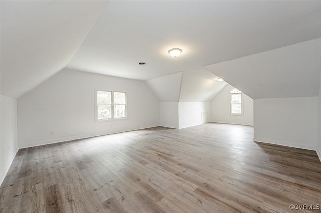 Bonus room featuring plenty of natural light, vaulted ceiling, wood finished floors, and baseboards | Image 28