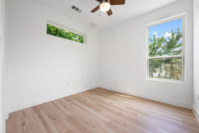 Spare room with healthy amount of natural light, ceiling fan, baseboards, and light wood-type flooring | Image 22