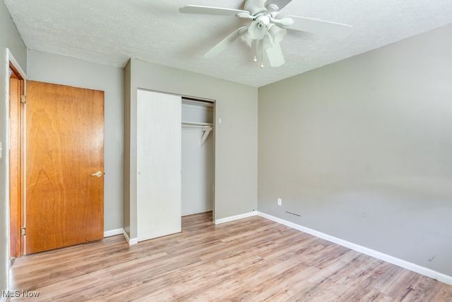Unfurnished bedroom with wood finished floors, a closet, a textured ceiling, and baseboards | Image 33