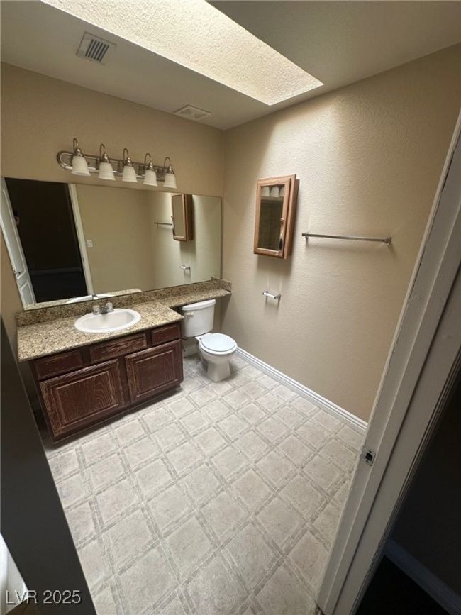 Bathroom with visible vents, baseboards, toilet, tile patterned floors, and vanity | Image 19
