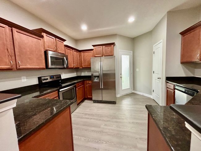 The kitchen offers lots of cabinet space and pantry. The granite countertops plus stainless steel appliances | Image 5