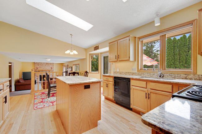 Kitchen with granite counters, center island, kitchen window peeking your pool. | Image 15