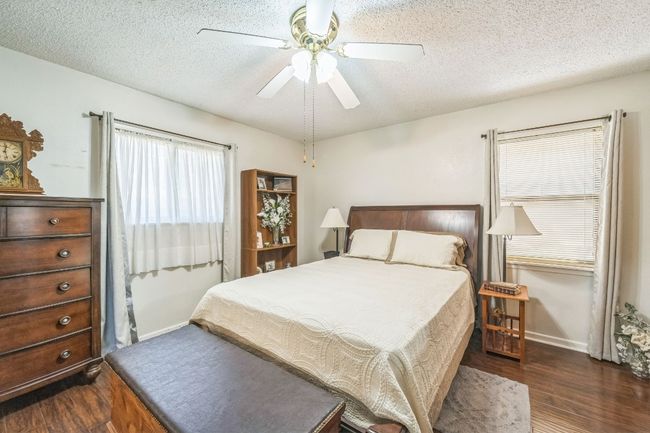 Bedroom featuring a textured ceiling, wood finished floors, ceiling fan, and baseboards | Image 17
