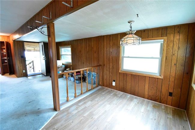 Unfurnished dining area with wooden walls and light wood-type flooring | Image 23