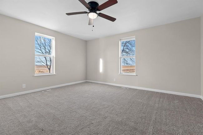Carpeted empty room featuring ceiling fan and baseboards | Image 11