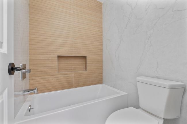 Full bath with tile walls, a tub, and toilet | Image 27