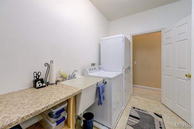 The galley laundry room connects the garage to the kitchen and has washer/dryer and utility sink. | Image 17