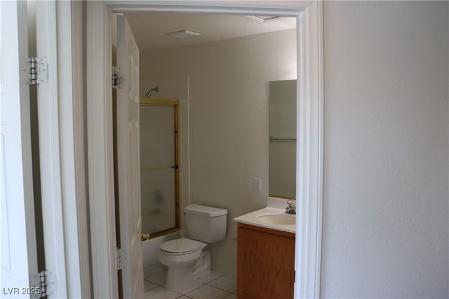 Bathroom with tile patterned flooring, vanity, and combined bath / shower with glass door | Image 52